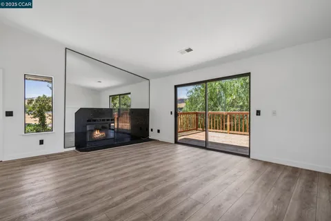 a view of empty room with wooden floor and fireplace