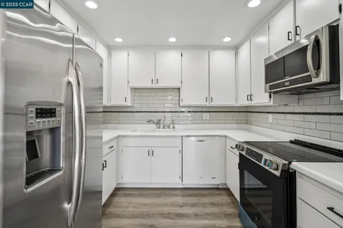 a kitchen with stainless steel appliances granite countertop a stove microwave and refrigerator
