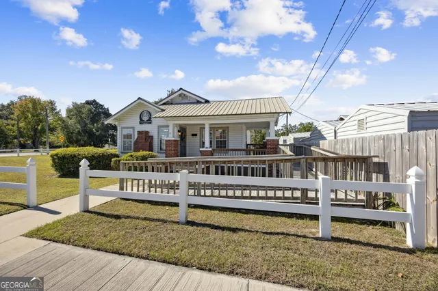 a view of a house with wooden deck and a backyard