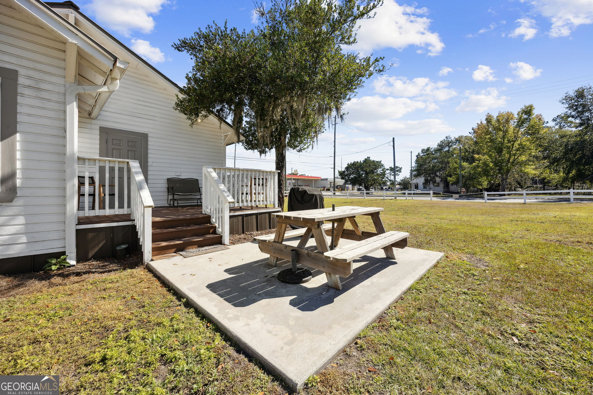 383 1st Street Folkston, GA 31537 - Photo 46 of 81 a view of a patio with dining table and chairs with wooden floor and fence