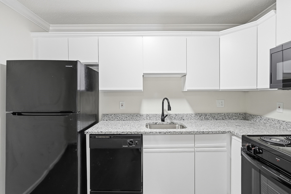 30 Abbey Road, Unit 102 Leominster, MA 01453 - Photo 8 of 15 a kitchen with stainless steel appliances granite countertop a refrigerator a sink and white cabinets