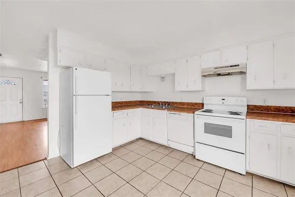 a kitchen with white cabinets and white appliances