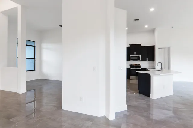 a view of an empty room with window and stairs