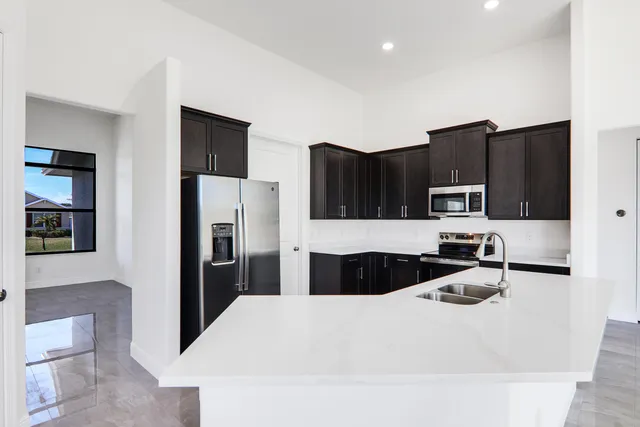 a kitchen with granite countertop a refrigerator and a stove top oven