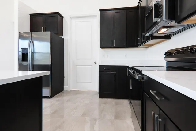 a kitchen with stainless steel appliances a sink and a refrigerator