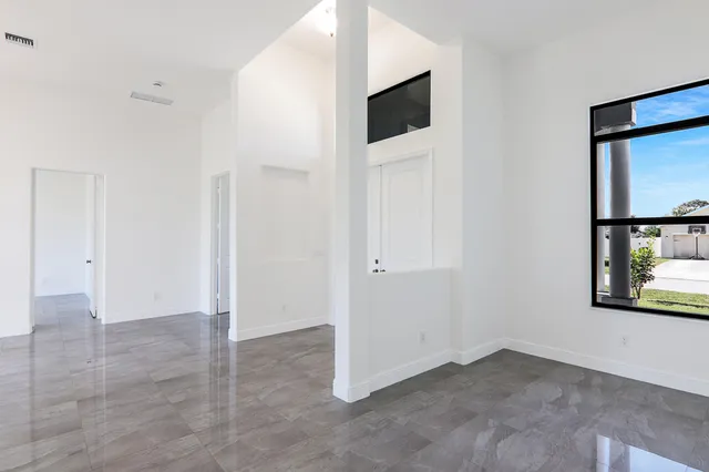 an empty room with windows and wardrobe