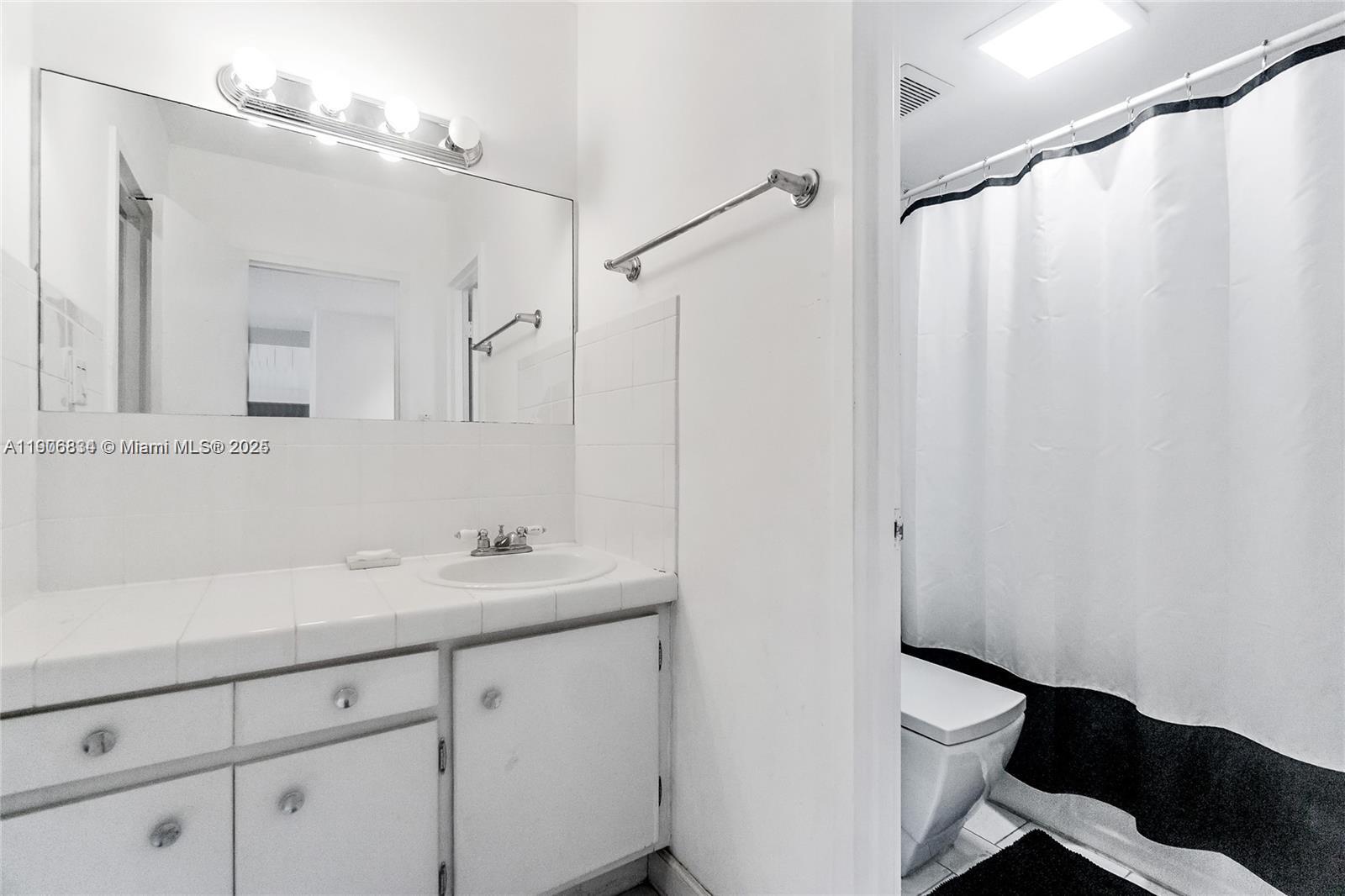 100 Lincoln Road, Unit 1201 Miami Beach, FL 33139 - Photo 11 of 19 a bathroom with a sink a toilet a mirror and shower