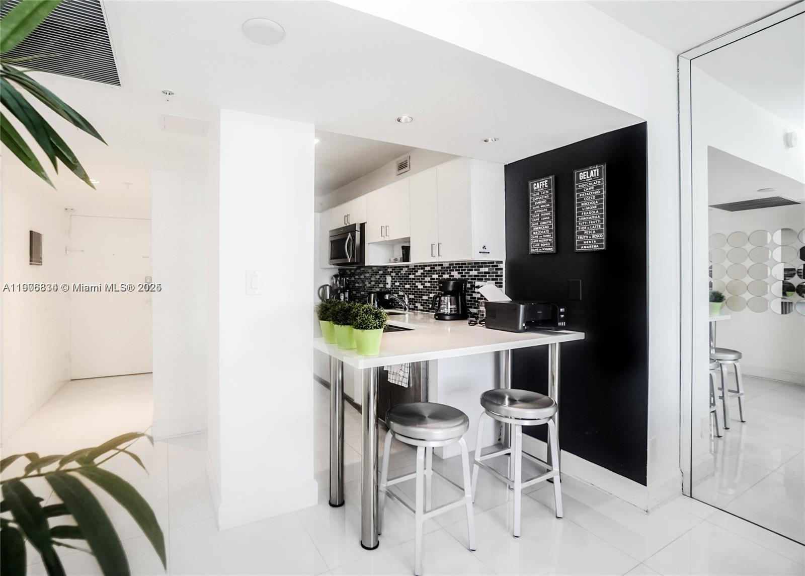 100 Lincoln Road, Unit 1201 Miami Beach, FL 33139 - Photo 7 of 19 a kitchen with a table and chairs