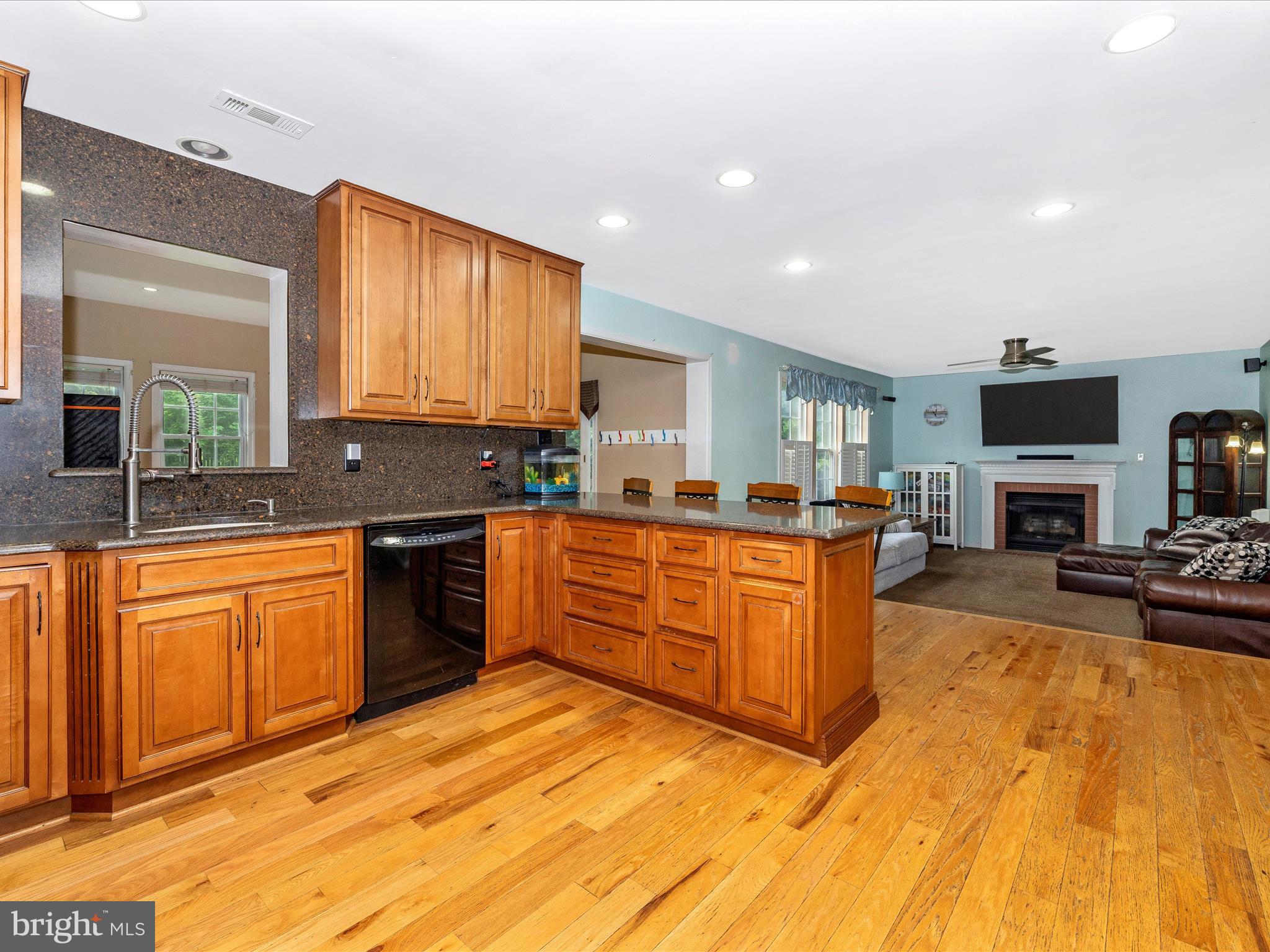 5880 Union Ridge Drive Adamstown, MD 21710 - Photo 14 of 49 a large kitchen with stainless steel appliances granite countertop a stove a sink dishwasher a microwave oven with cabinets and wooden floor
