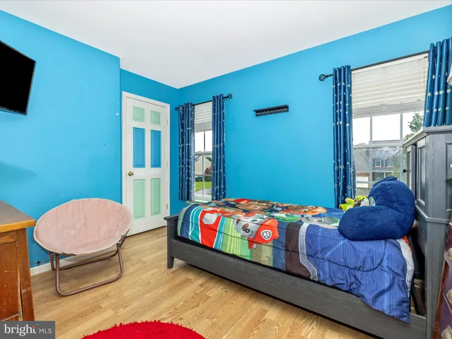 a bedroom with a bed a window and a flat screen tv