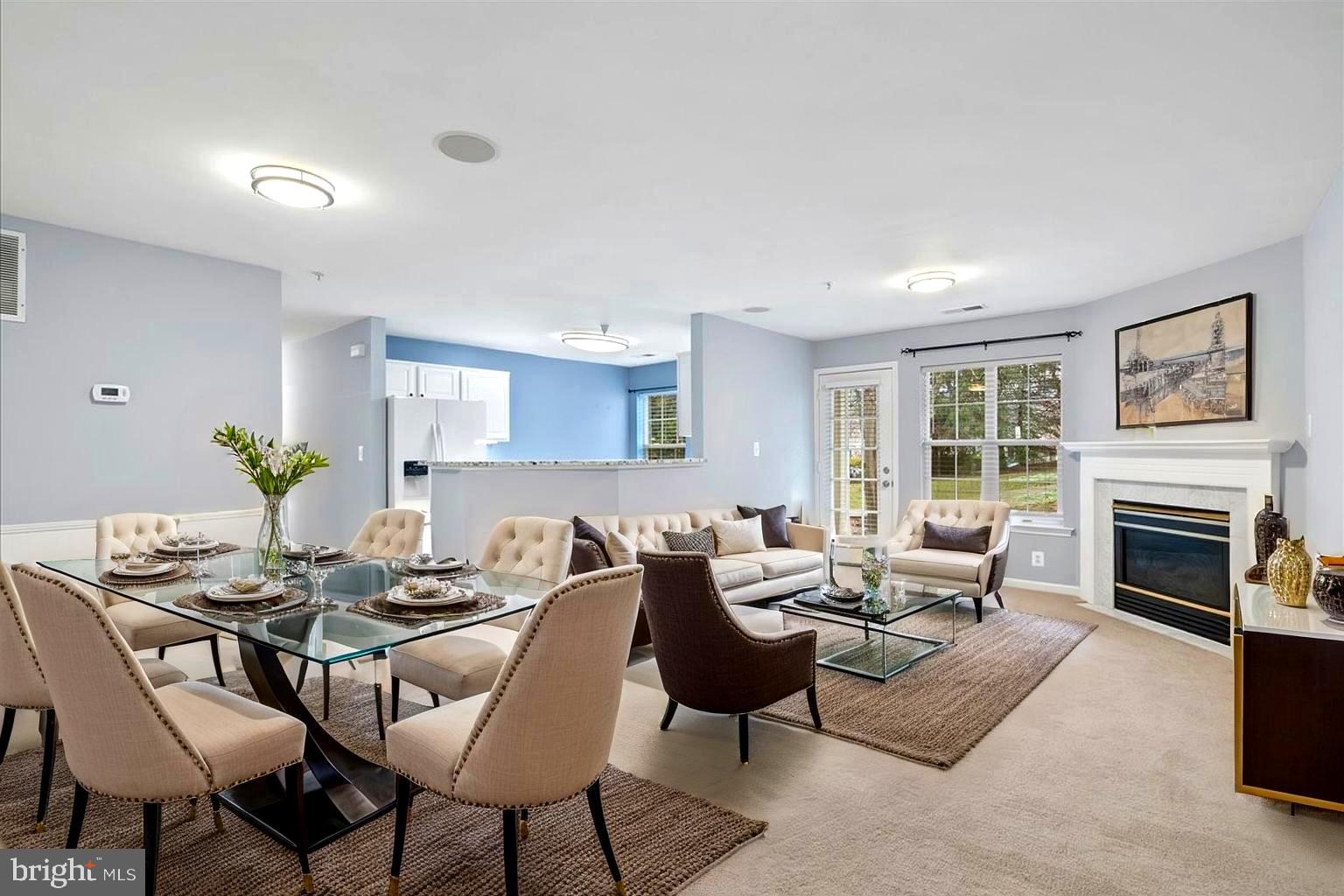 a living room with furniture a fireplace and a large window