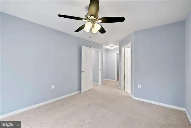 a view of an empty room and a ceiling fan
