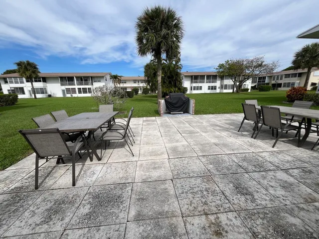 a view of a patio with a dining table and chairs with a fire pit