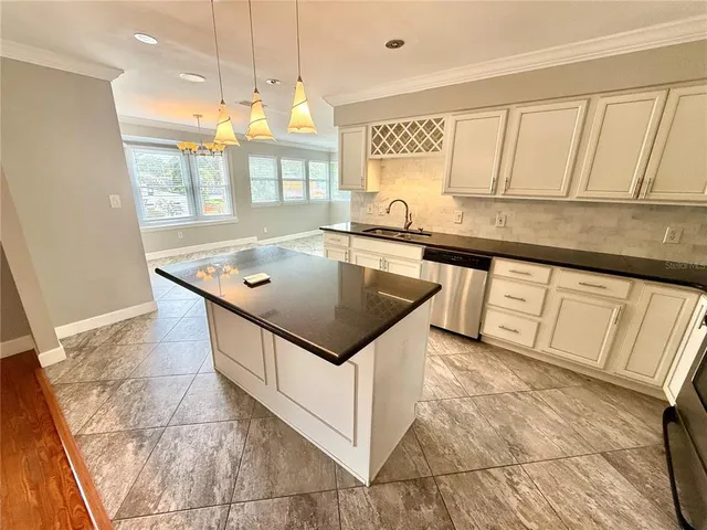 a kitchen with stainless steel appliances granite countertop a sink and a white cabinets