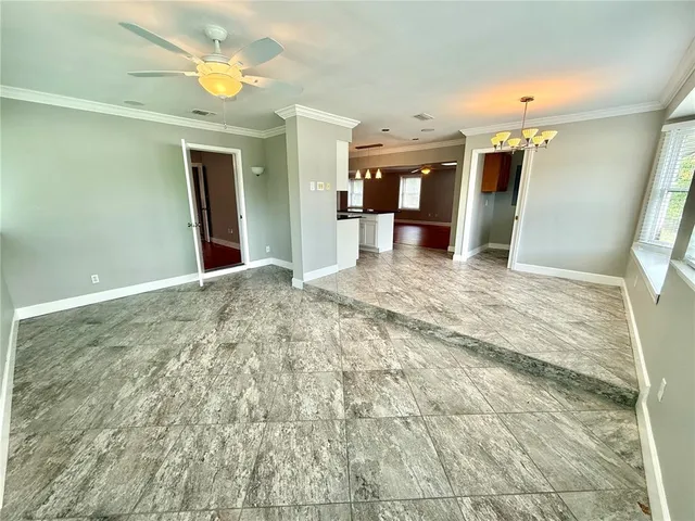 a view of a big room with wooden floor and windows