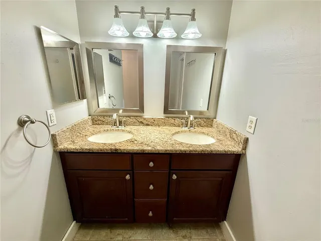 a bathroom with a granite countertop sink and a mirror