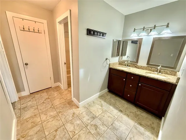 a spacious bathroom with a granite countertop sink and a mirror