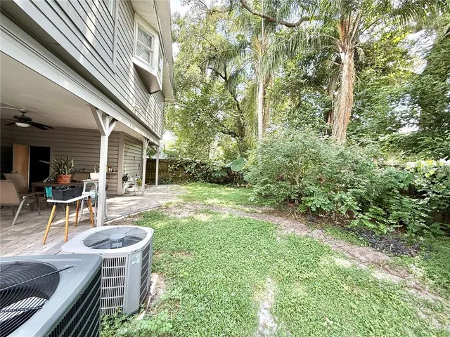 a view of a patio with table and chairs and potted plants with wooden floor and fence