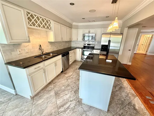 a kitchen with stainless steel appliances granite countertop sink stove top oven and cabinets