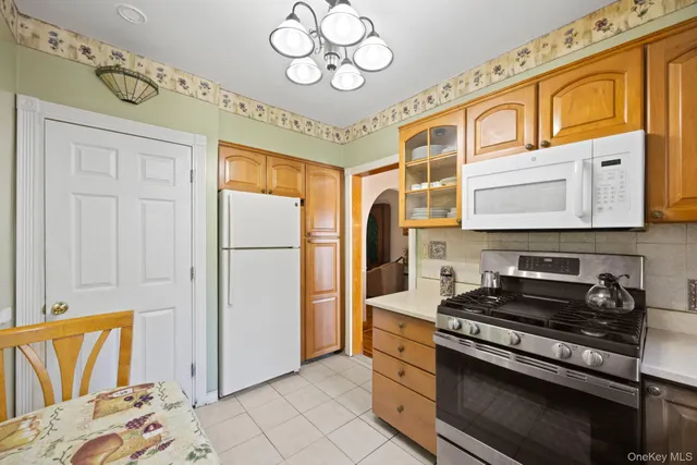 a kitchen with stainless steel appliances granite countertop a stove a refrigerator and a microwave