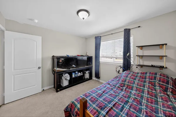 a bedroom with a bed dresser and a window