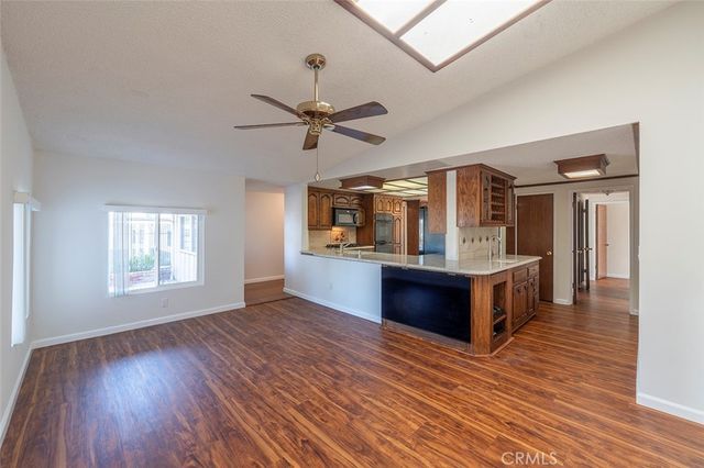 a view of living room with kitchen island with wooden floor and fan