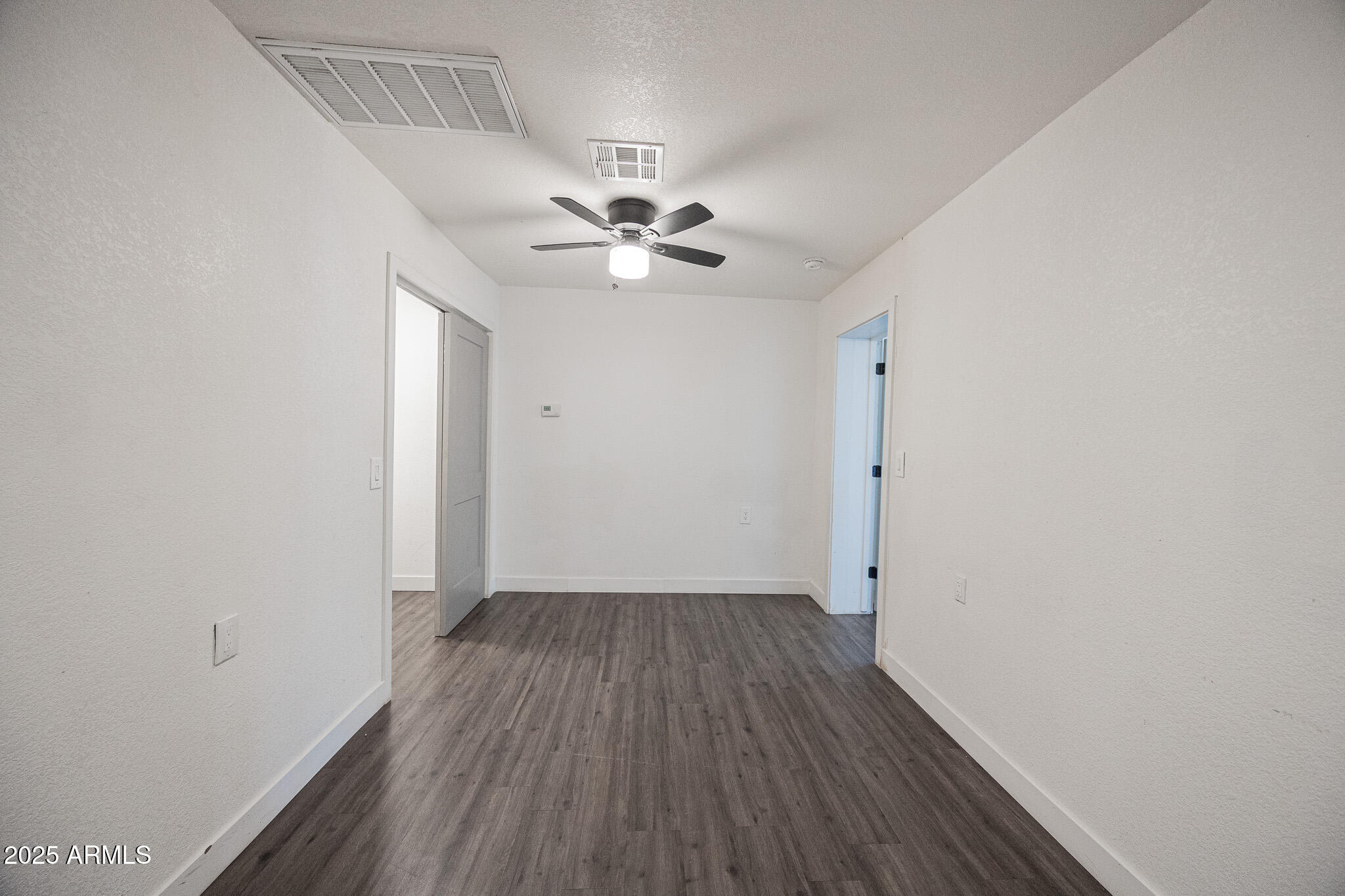 2802 North 36th Street, Unit 3 Phoenix, AZ 85008 - Photo 12 of 23 an empty room with wooden floor and a ceiling fan