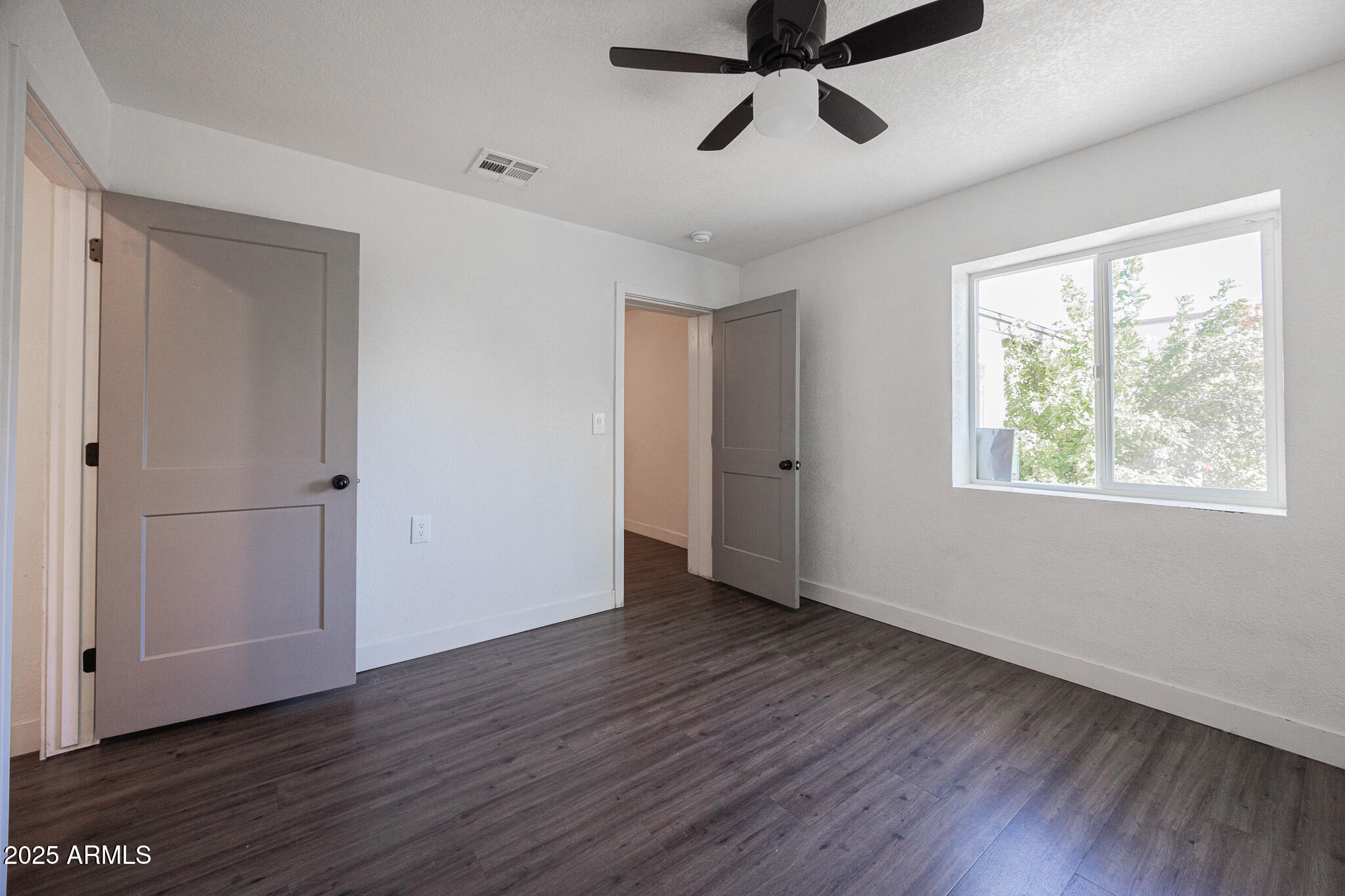 2802 North 36th Street, Unit 3 Phoenix, AZ 85008 - Photo 16 of 23 a view of an empty room with wooden floor and a window