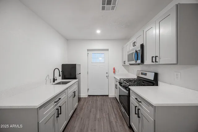 a kitchen with a stove a sink and a refrigerator
