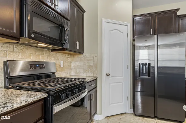 a kitchen with stainless steel appliances granite countertop a stove microwave and refrigerator