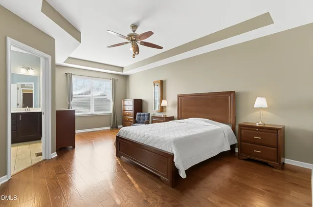 a spacious bedroom with a bed and wooden floor