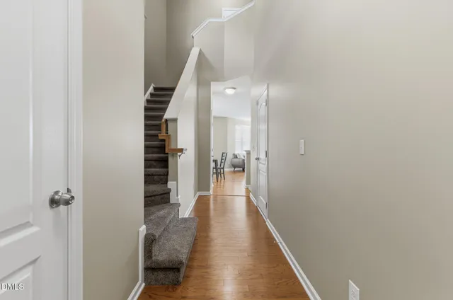 a view of a hallway with wooden floor and staircase