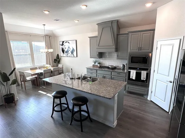 a kitchen with granite countertop white cabinets and stainless steel appliances