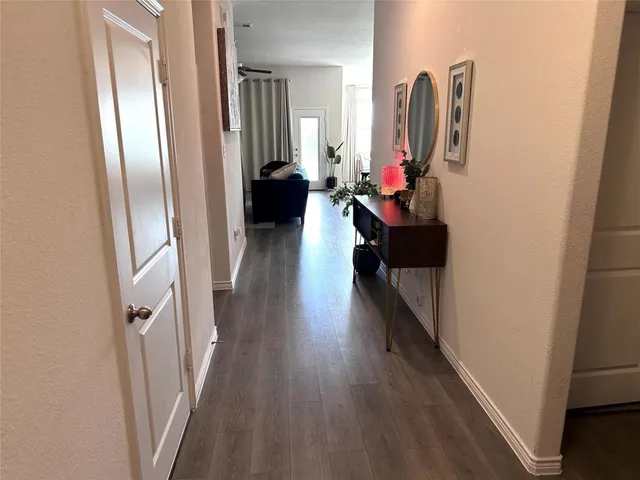 a view of a hallway with wooden floor and stairs