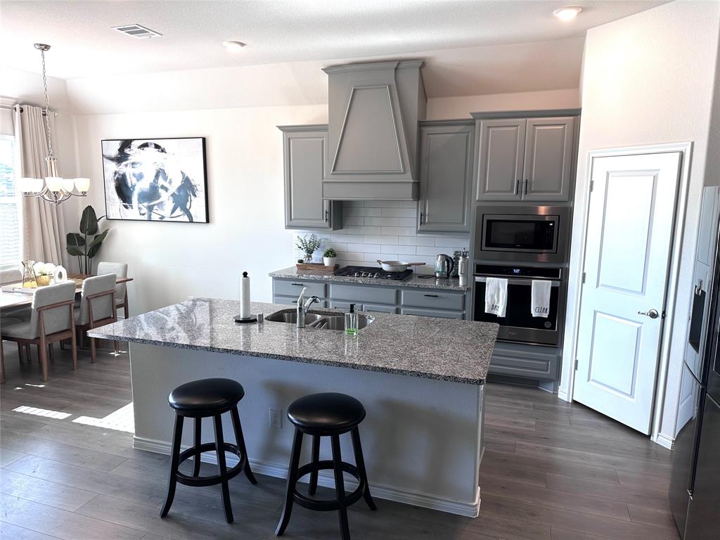 1016 Sublime Drive Forney, TX 75126 - Photo 2 of 15 a kitchen with stainless steel appliances granite countertop a table chairs microwave and sink