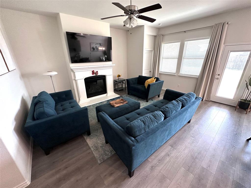 1016 Sublime Drive Forney, TX 75126 - Photo 5 of 15 a living room with furniture a flat screen tv and a fireplace