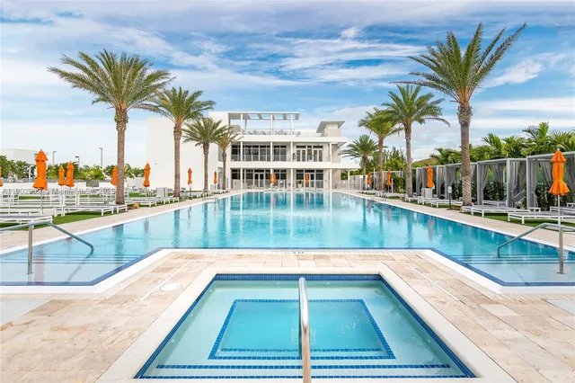 a view of swimming pool with outdoor seating and house in the background