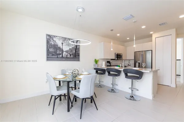 a living room with furniture kitchen and a dining table with kitchen view