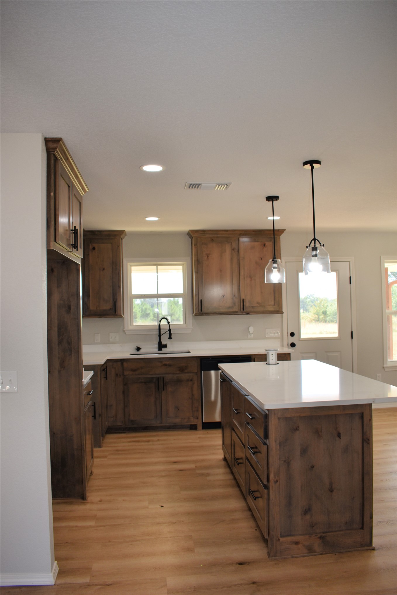 2915 East 2090 Road Hugo, OK 74743 - Photo 5 of 27 Wood-finish flooring, recessed lighting, wood cabinetry, large center island with countertop, and stainless steel dishwasher