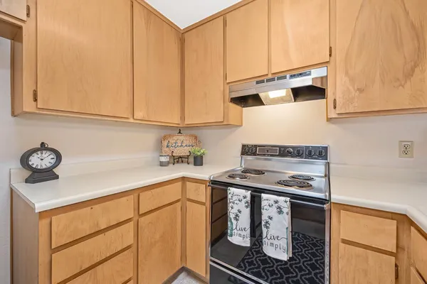 a kitchen with stainless steel appliances a stove a sink and cabinets