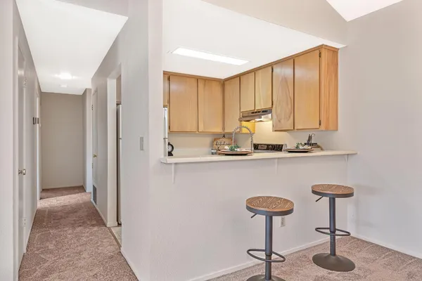 a kitchen with stainless steel appliances granite countertop a sink a refrigerator and a counter top space
