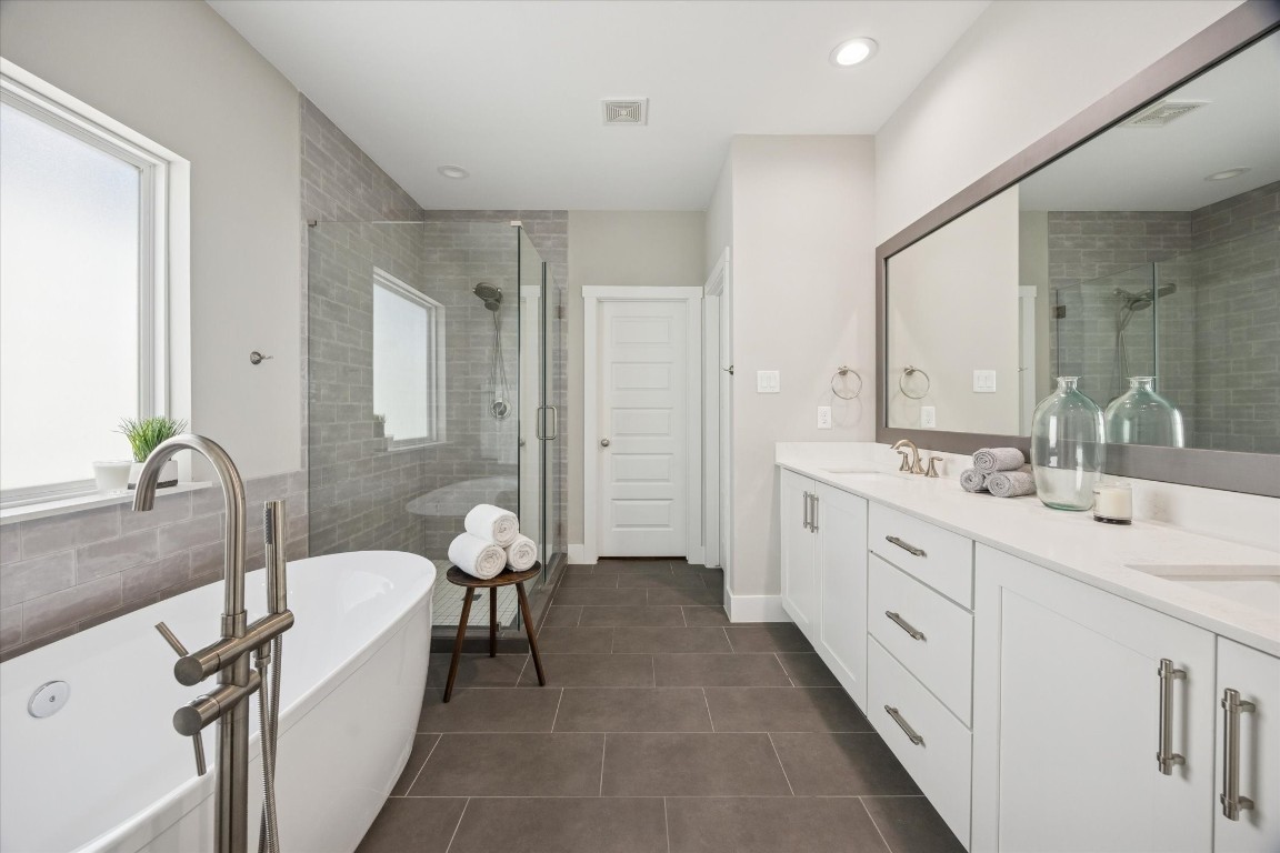 920 West 25th Street, Unit B Houston, TX 77008 - Photo 19 of 35 a bathroom with double vanity sink a two mirror a bathtub and shower