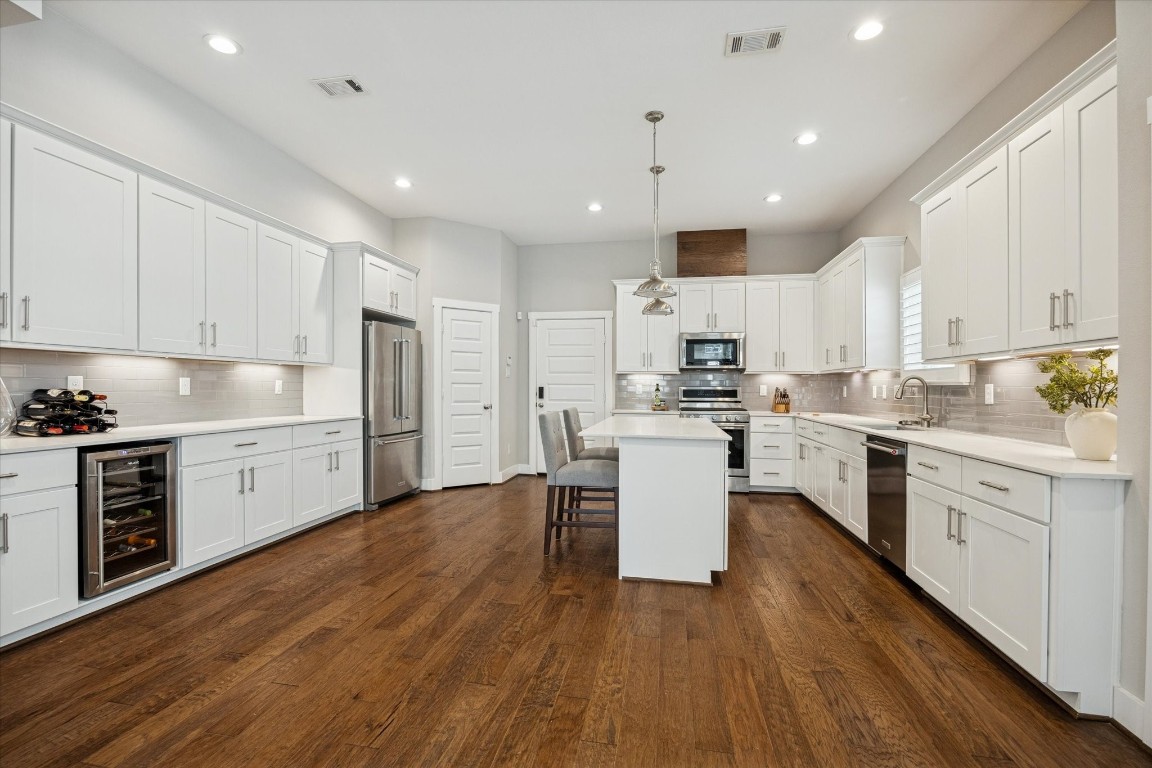 920 West 25th Street, Unit B Houston, TX 77008 - Photo 6 of 35 a kitchen with kitchen island granite countertop a sink cabinets and wooden floor
