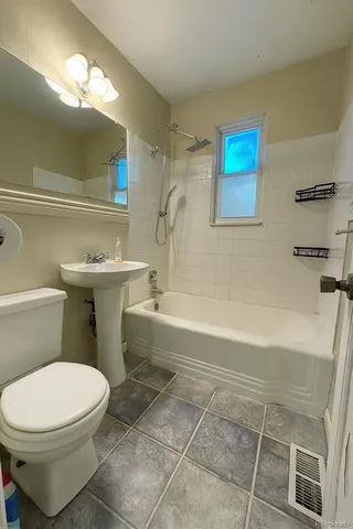 a bathroom with a toilet a sink and bathtub