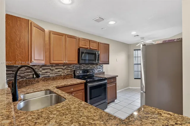 a kitchen with stainless steel appliances granite countertop a sink stove and refrigerator