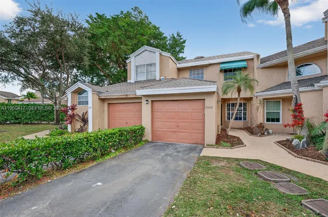 a front view of a house with a garden and plants