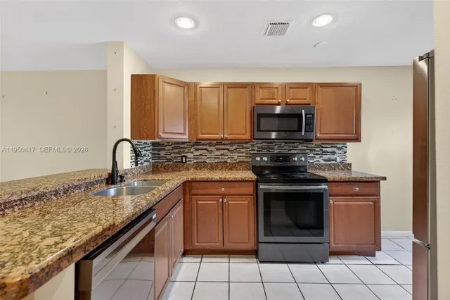 a kitchen with granite countertop a stove sink and cabinets