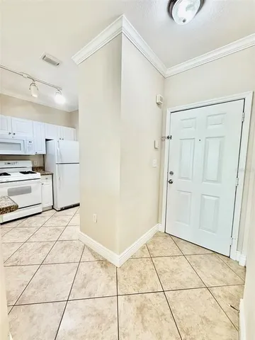 a view of a kitchen with wooden floor and a refrigerator