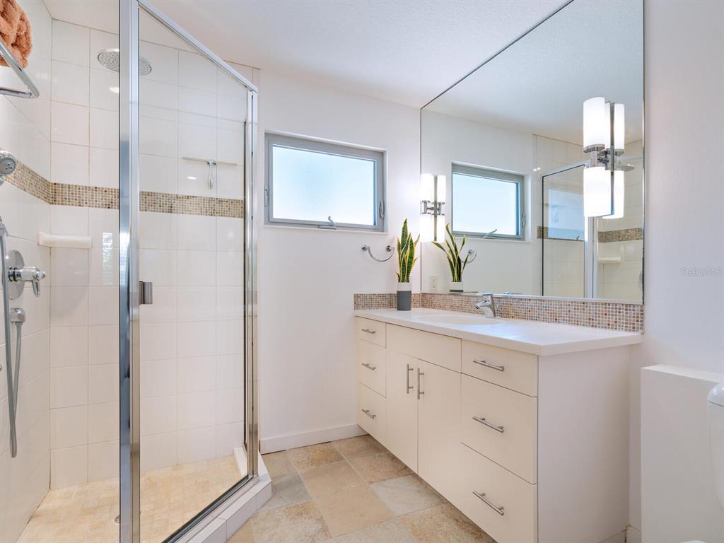 3201 Casey Key Road Nokomis, FL 34275 - Photo 23 of 98 a bathroom with a double vanity sink and mirror