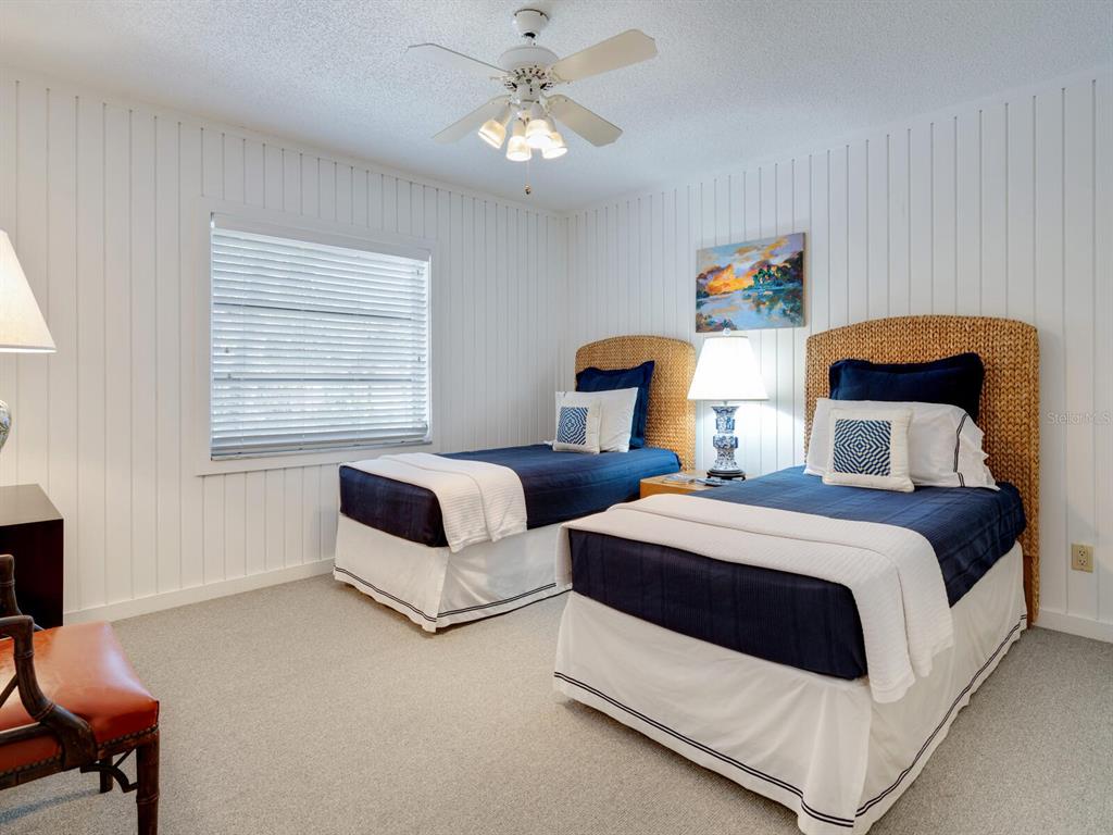3201 Casey Key Road Nokomis, FL 34275 - Photo 24 of 98 a bedroom with two beds and a chandelier